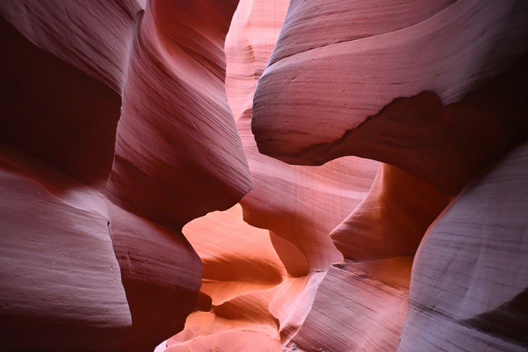 Narrow passage framed by smooth red sandstone walls in Antelope Canyon
